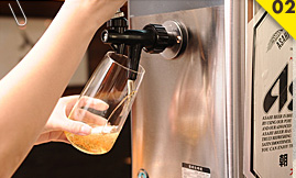接着右手将把手往前推，新鲜的啤酒就顺着杯壁直下。